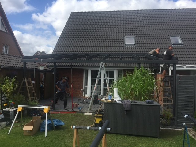 Hiller-Monteure bei der Arbeit an einer Terrassenüberdachung im Garten