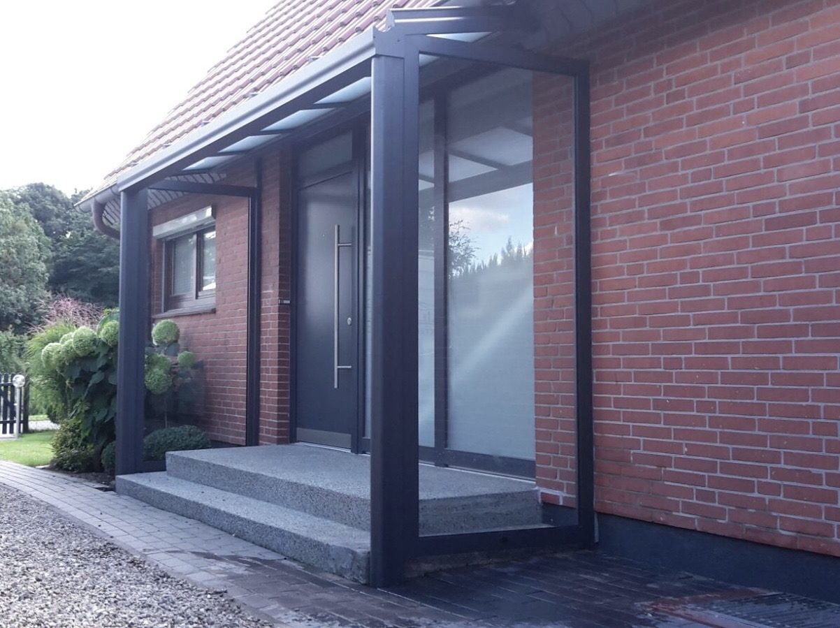 Aluminium-Vordach auf Stützen über einem Hauseingang mit Glaseindeckung