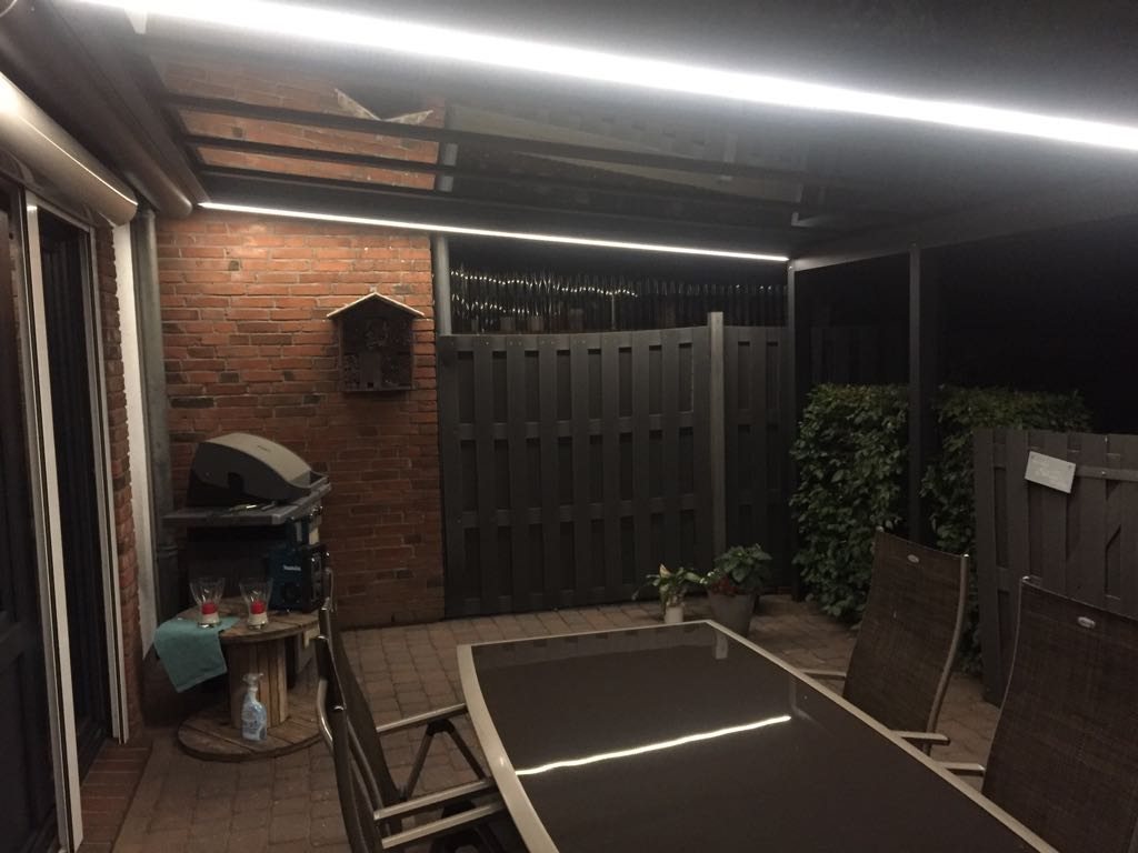 Terrasse bei Nacht, beleuchtet durch LED-Leisten im Sonnenschutz